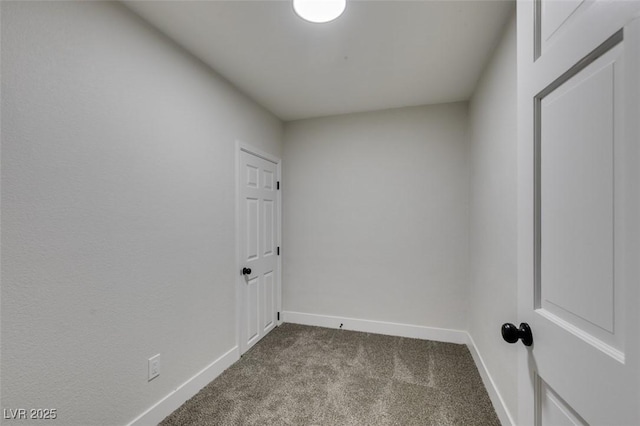 unfurnished room with baseboards and dark colored carpet