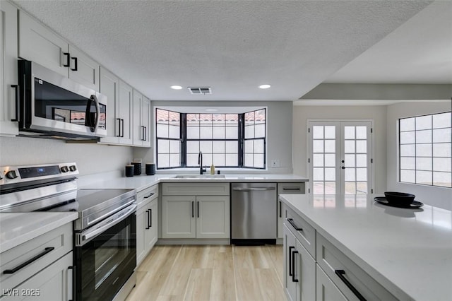 kitchen featuring light countertops, visible vents, appliances with stainless steel finishes, and a sink