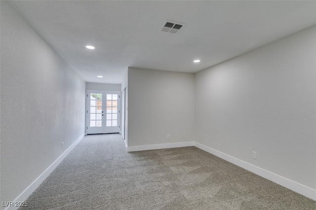 carpeted spare room featuring recessed lighting, french doors, baseboards, and visible vents