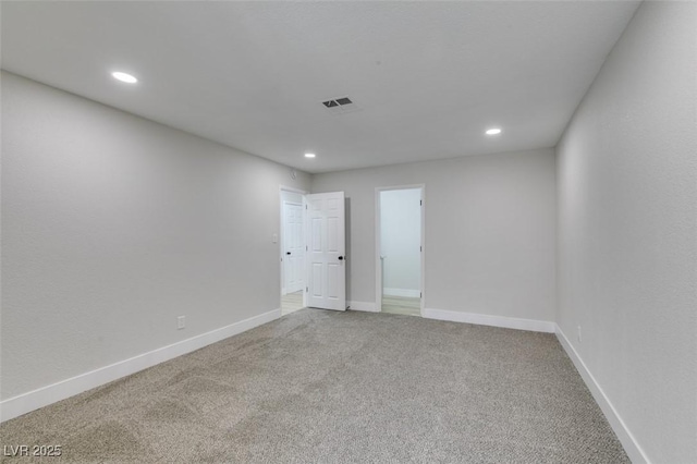 spare room with recessed lighting, carpet flooring, baseboards, and visible vents