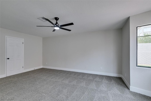 empty room featuring a wealth of natural light, carpet flooring, baseboards, and visible vents