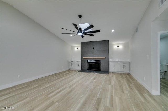 unfurnished living room with visible vents, a fireplace, light wood-type flooring, and baseboards