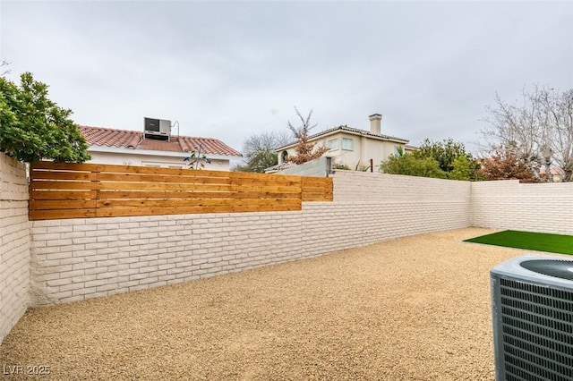 view of yard with a fenced backyard and central AC