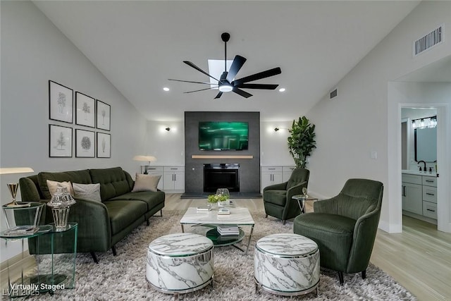 living area with visible vents, lofted ceiling, recessed lighting, light wood-style floors, and a ceiling fan