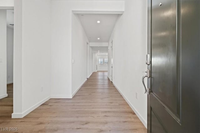 hallway with light wood-style floors, recessed lighting, and baseboards