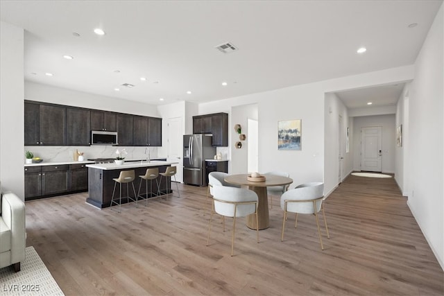 dining area with light wood-type flooring, visible vents, and recessed lighting