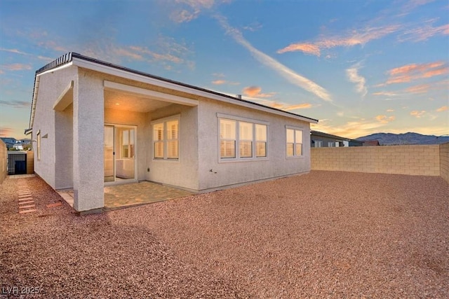 back of property with a patio area, a fenced backyard, and stucco siding