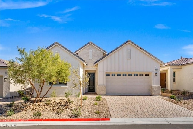 view of front of home featuring a tiled roof, decorative driveway, an attached garage, and board and batten siding