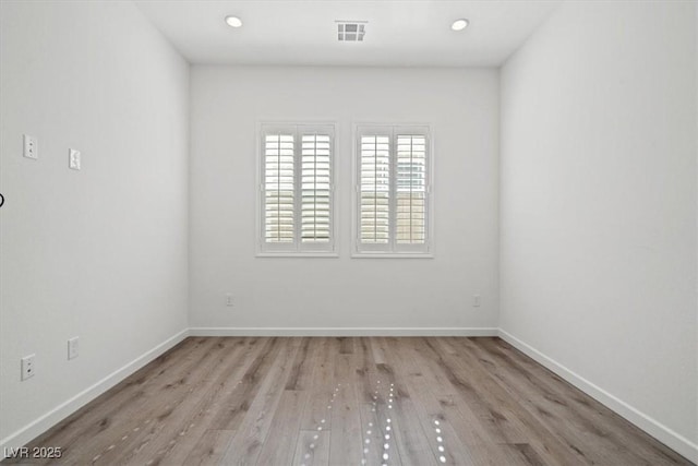 empty room with baseboards, visible vents, wood finished floors, and recessed lighting