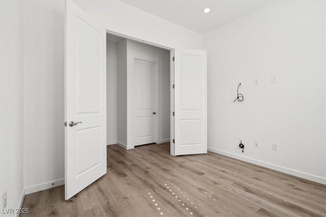 unfurnished bedroom with recessed lighting, wood finished floors, and baseboards