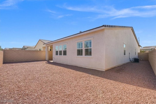 rear view of property with a fenced backyard and stucco siding