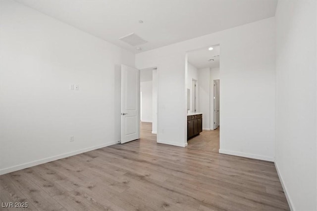 spare room featuring light wood-style floors and baseboards