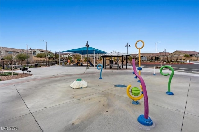 view of home's community with fence, playground community, and a gazebo