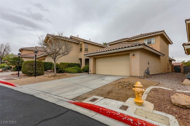 mediterranean / spanish house featuring driveway, an attached garage, a tile roof, and stucco siding