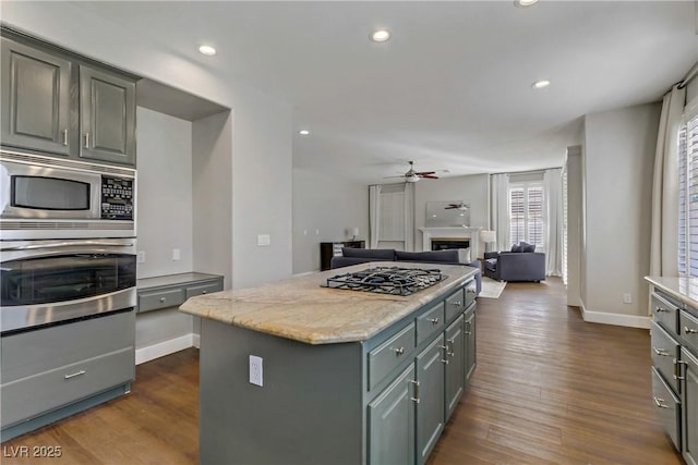 kitchen with dark wood-style floors, gray cabinets, stainless steel appliances, and a center island