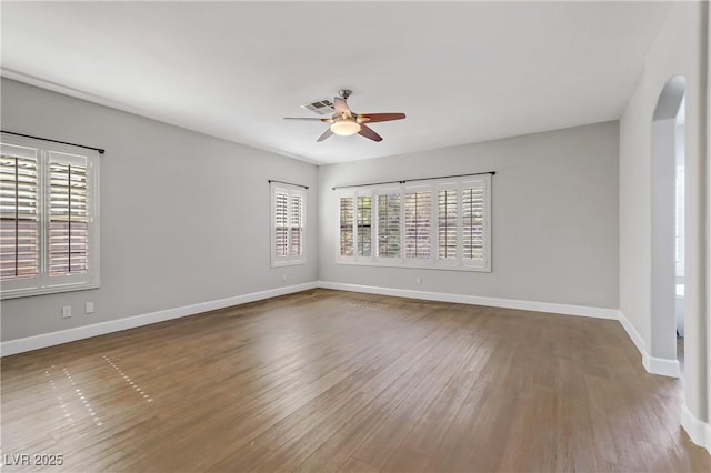 unfurnished room with a wealth of natural light, baseboards, and wood finished floors