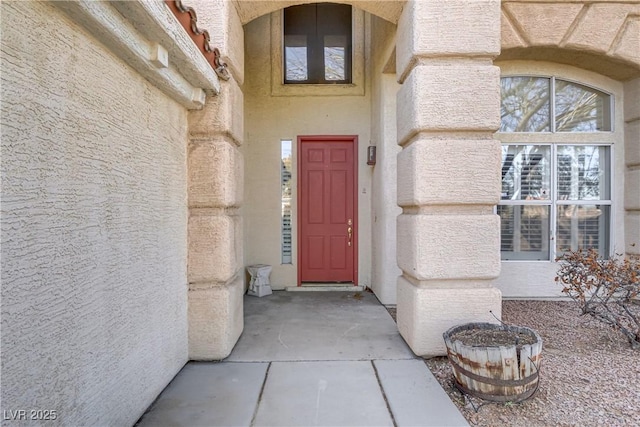 view of exterior entry featuring stucco siding