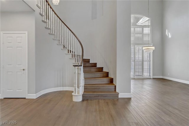 stairs featuring wood finished floors and baseboards