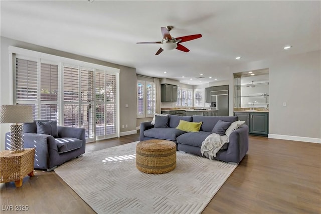 living area with dark wood-style floors, recessed lighting, ceiling fan, and baseboards