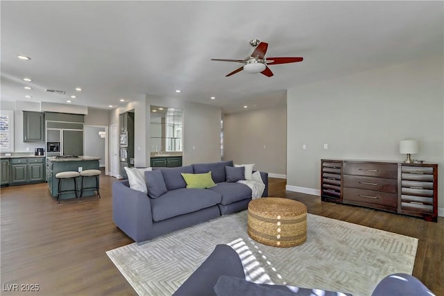 living area with visible vents, baseboards, dark wood-style flooring, and recessed lighting