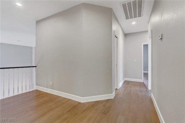 hallway featuring recessed lighting, light wood-type flooring, visible vents, and baseboards