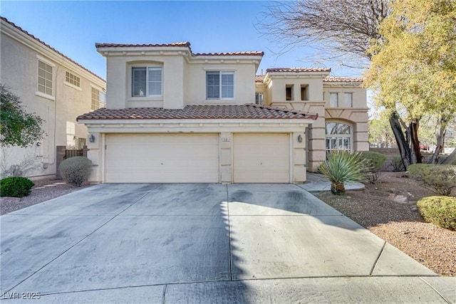 mediterranean / spanish house with concrete driveway, an attached garage, a tiled roof, and stucco siding