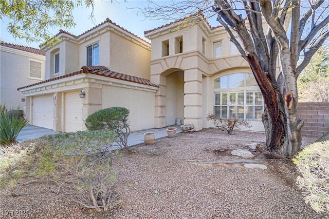 view of front of house with a garage, a tile roof, and stucco siding