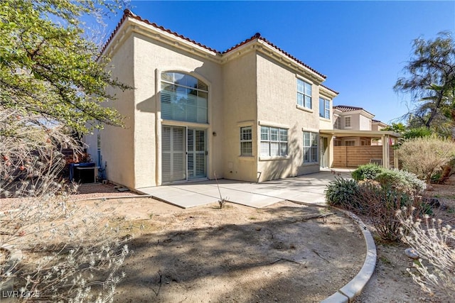 back of house with a patio area, a tiled roof, and stucco siding