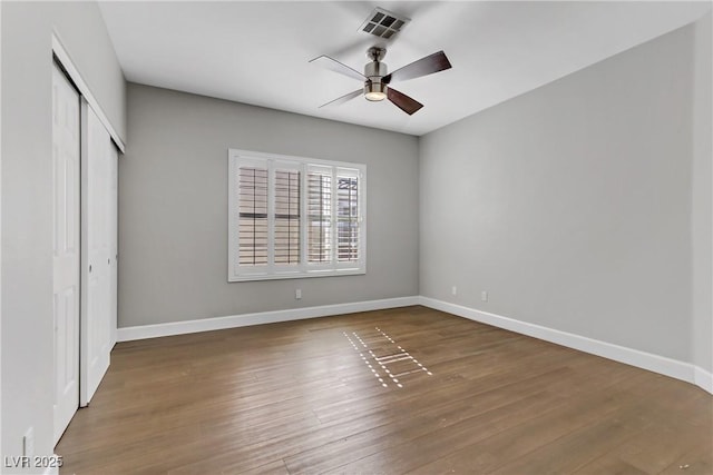 unfurnished bedroom featuring baseboards, a closet, visible vents, and wood finished floors