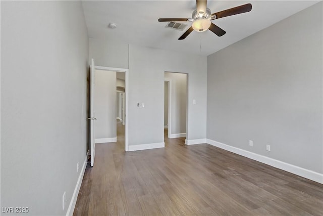 unfurnished bedroom featuring a ceiling fan, wood finished floors, visible vents, and baseboards