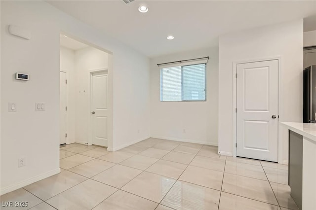 unfurnished room with recessed lighting, light tile patterned flooring, and baseboards