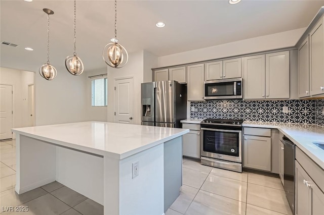 kitchen featuring visible vents, a kitchen island, appliances with stainless steel finishes, and gray cabinets