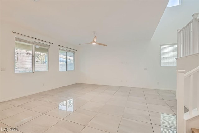 empty room featuring stairs, ceiling fan, and light tile patterned floors