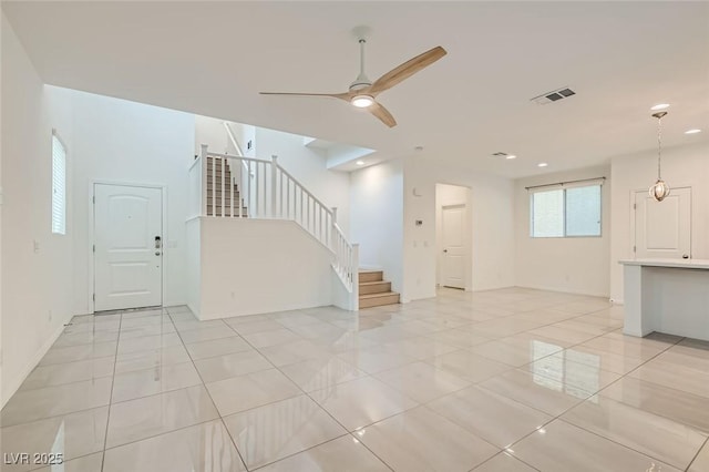 unfurnished living room featuring light tile patterned floors, recessed lighting, visible vents, a ceiling fan, and stairs