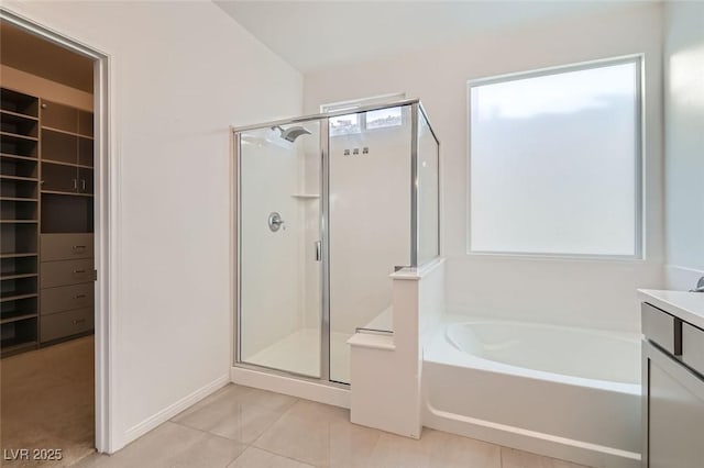 full bath featuring a stall shower, a spacious closet, a bath, and tile patterned floors