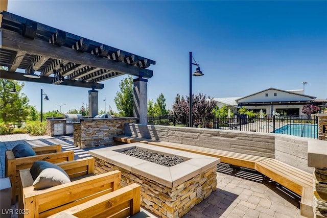 view of patio featuring a fire pit, area for grilling, fence, exterior kitchen, and a pergola