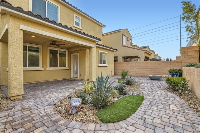 back of house with a patio area, fence, and stucco siding