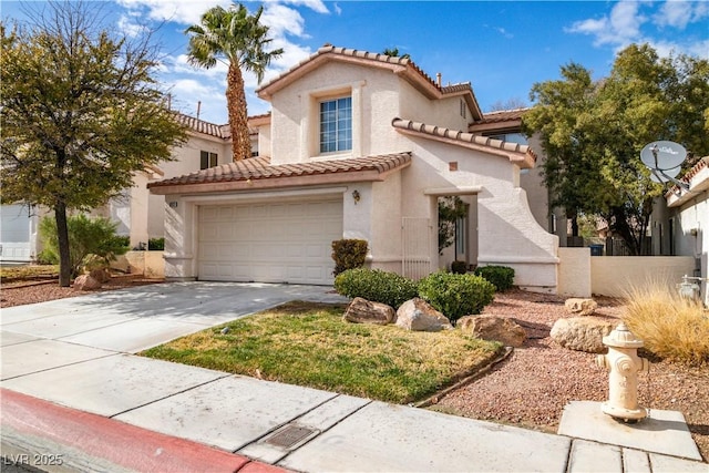 mediterranean / spanish house with a garage, concrete driveway, a tile roof, and stucco siding