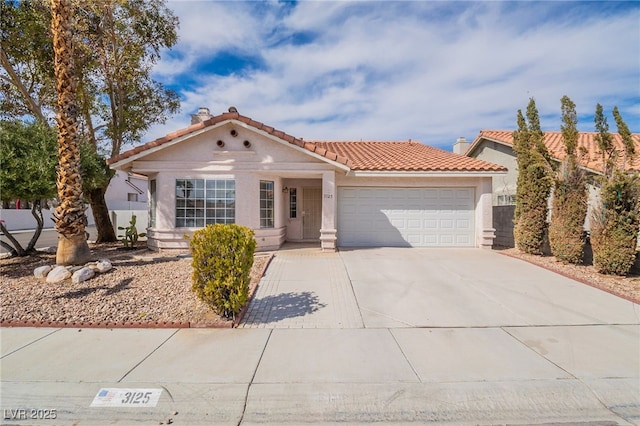 mediterranean / spanish-style house featuring a garage, driveway, a chimney, a tiled roof, and stucco siding