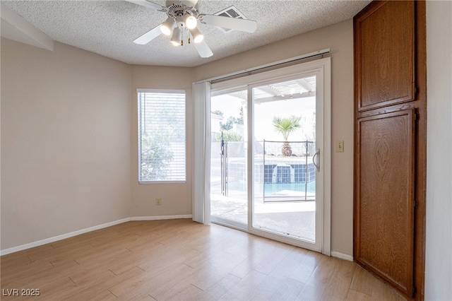 entryway featuring light wood finished floors, visible vents, baseboards, ceiling fan, and a textured ceiling