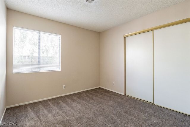 unfurnished bedroom with carpet floors, a closet, and a textured ceiling