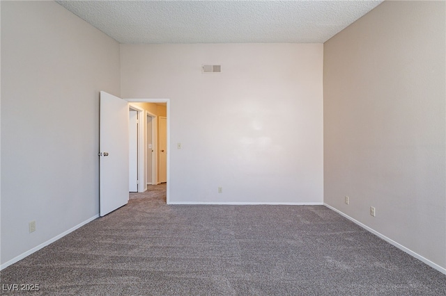 unfurnished room with a textured ceiling, carpet floors, visible vents, and baseboards