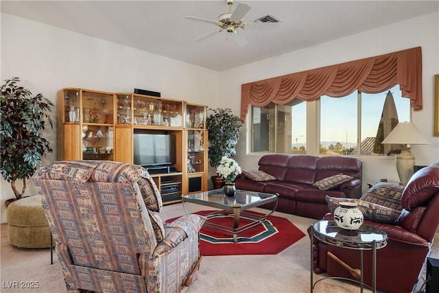 living room with visible vents, ceiling fan, and carpet flooring