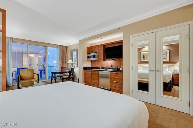 bedroom featuring access to exterior, ornamental molding, a sink, and french doors