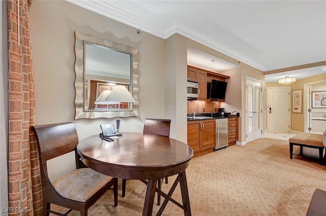 dining space with baseboards and crown molding