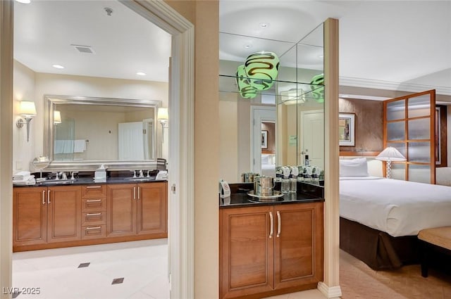 ensuite bathroom featuring double vanity, visible vents, a sink, and ensuite bathroom