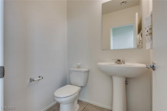 half bathroom with tile patterned flooring, baseboards, visible vents, and toilet