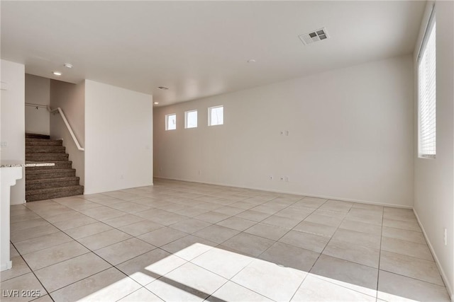 empty room featuring light tile patterned floors, stairs, visible vents, and recessed lighting