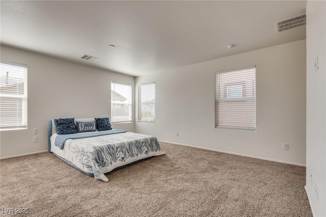 carpeted bedroom featuring visible vents and baseboards