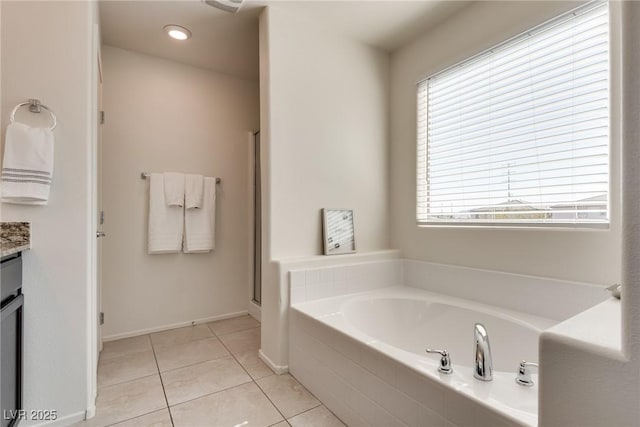 full bath with a garden tub, tile patterned flooring, vanity, and a healthy amount of sunlight